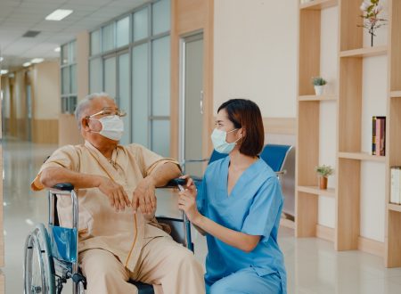 Young Asian woman nurse caregiver wear medical face mask encourage take care her patient explain.