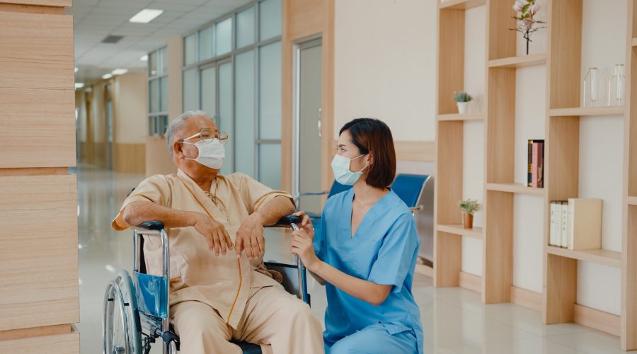 Young Asian woman nurse caregiver wear medical face mask encourage take care her patient explain.